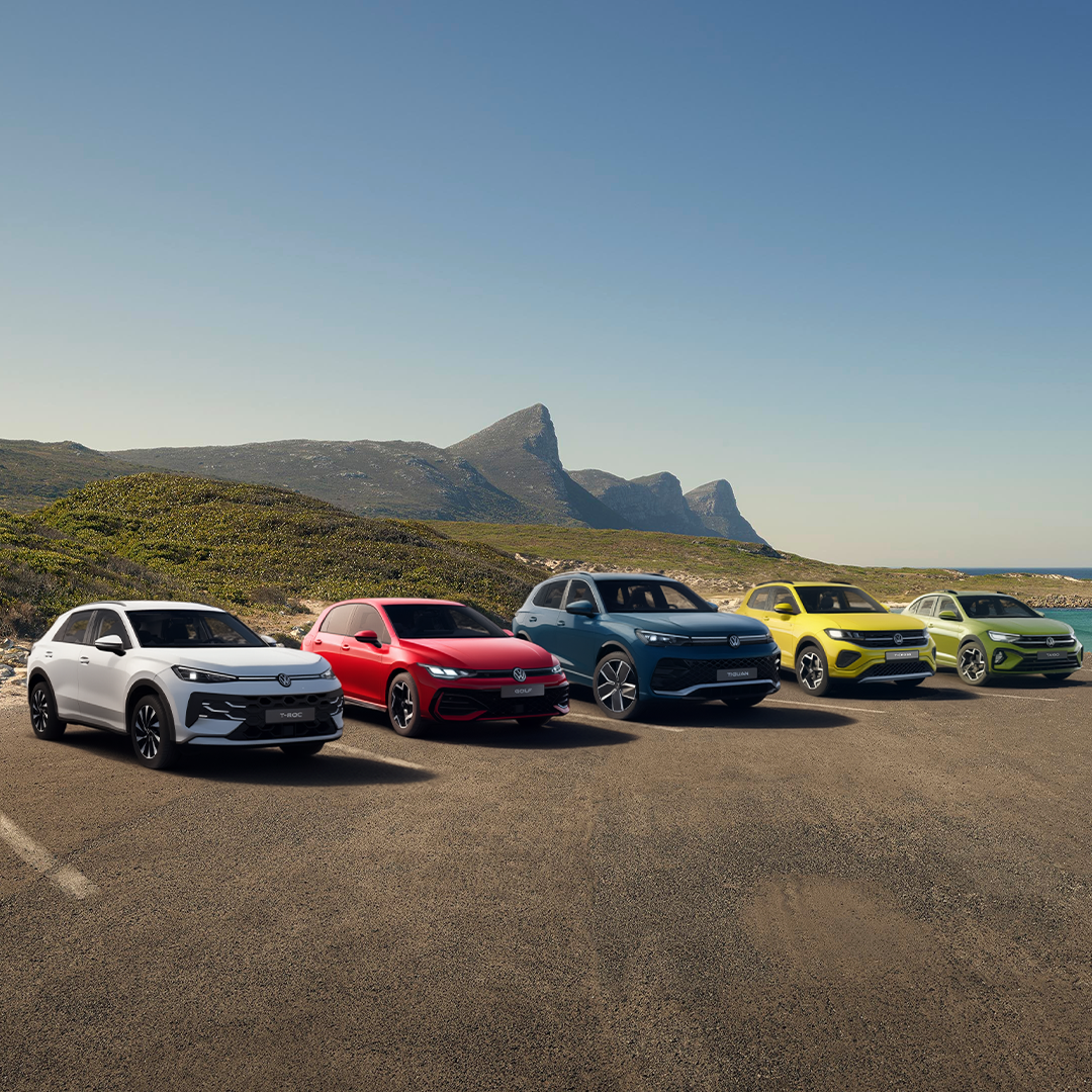 Mai multe modele Volkswagen hibrid (T-Roc, Golf, Tiguan, T-Cross si Taigo) afișate aliniat pe o șosea de coastă.