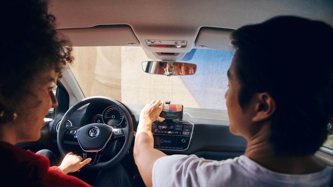 Zwei Personen bedienen Radio im VW up!