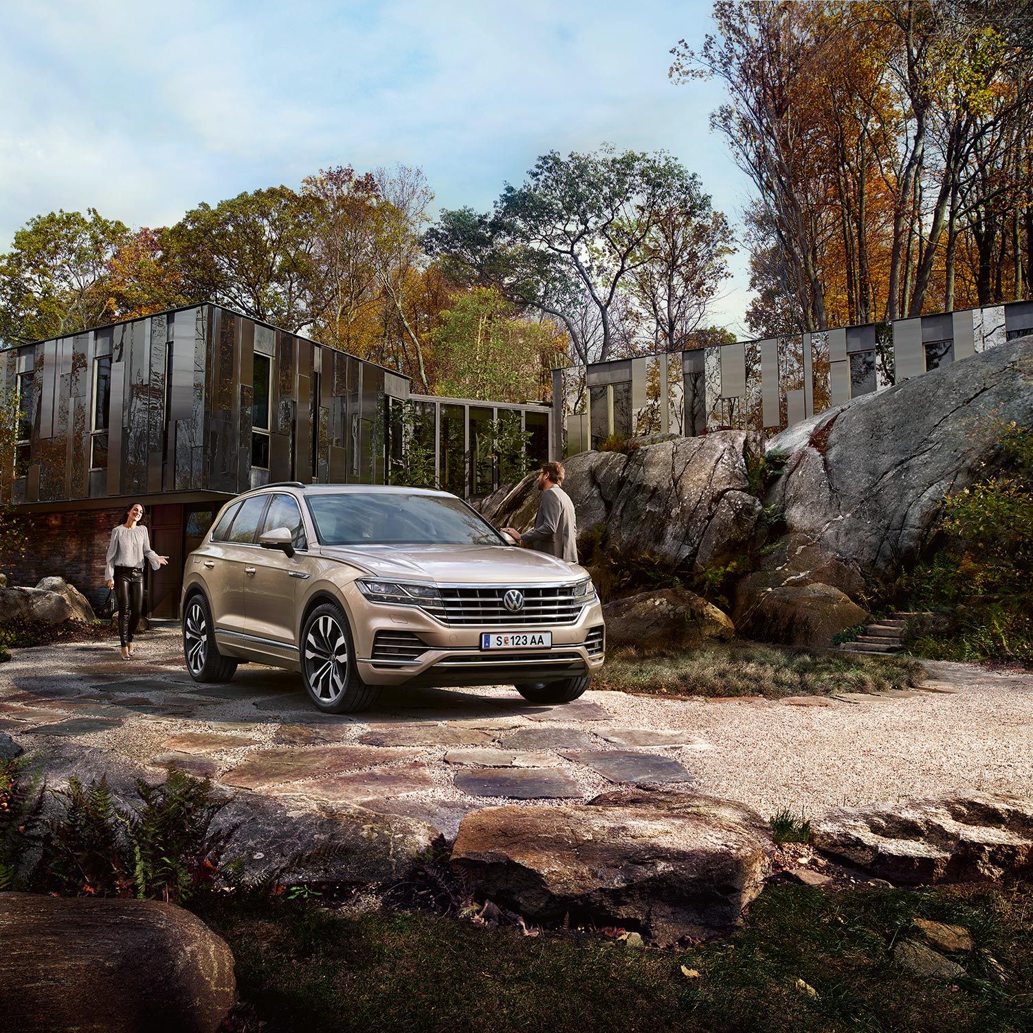 Ein VW Touareg steht geparkt in einer Einfahrt vor einem Haus, umgeben von großen Steinen 