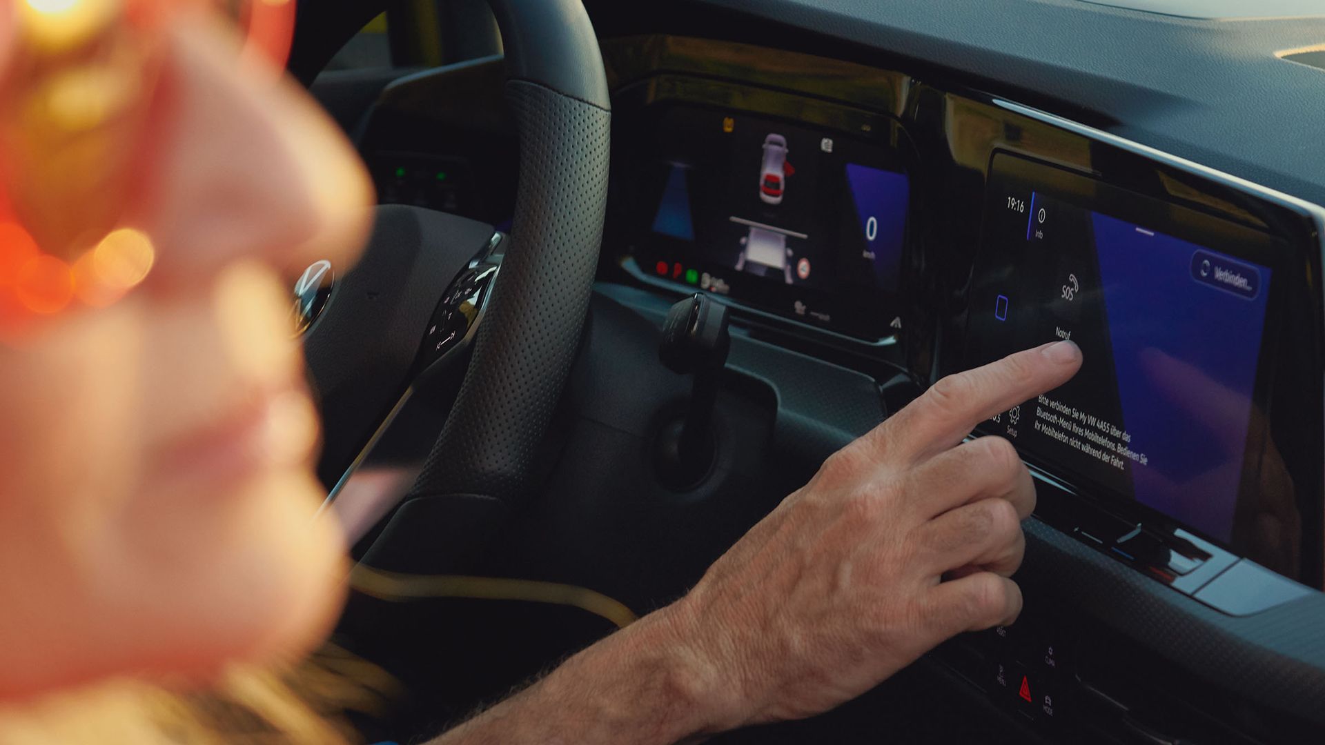 Eine Mann sitzt auf dem Fahrersitz VW Golf und schaut bedient  das Discover Pro 