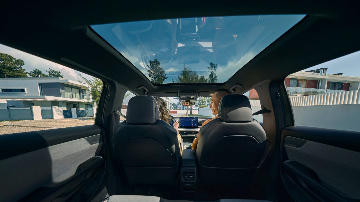 Blick von der Rücksitzbank zu den Frontsitzen eines VW ID. Cross, dort sitzen zwei Personen und unterhalten sich.