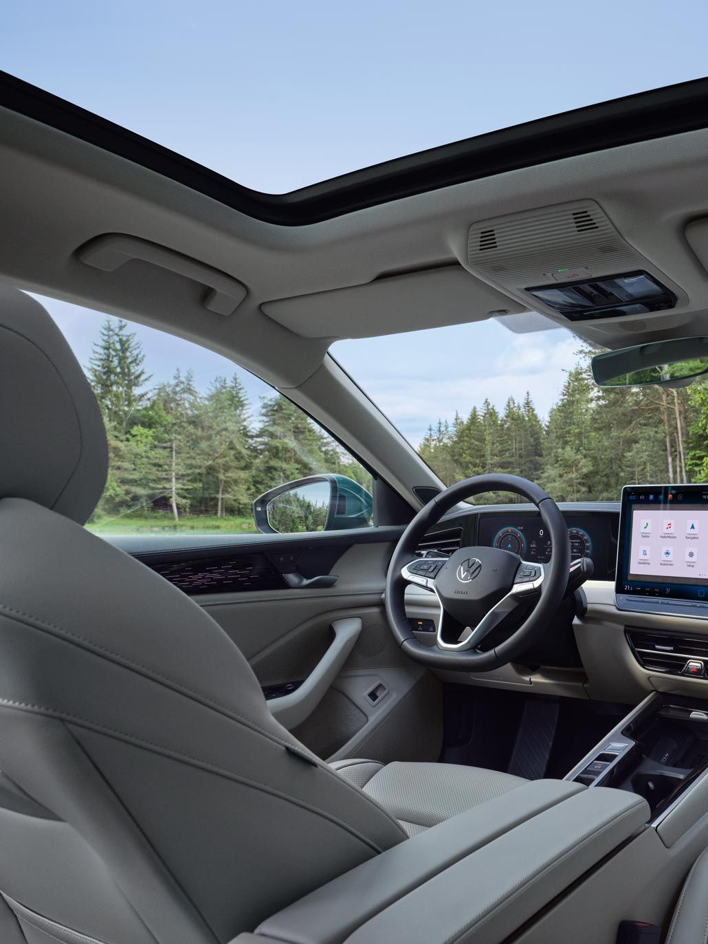 Vedere interioară a modelului VW Passat cu perspectivă asupra scaunelor opționale ergoActive, postului de conducere și Jumbobox-ului.