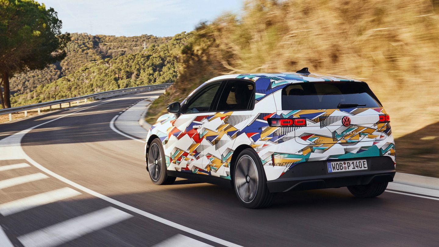 Un ID. Polo cu o vopsea colorată merge pe un drum șerpuit printr-un peisaj deluros. Pe partea dreaptă a drumului poți vedea copaci și tufișuri. Cerul e senin.