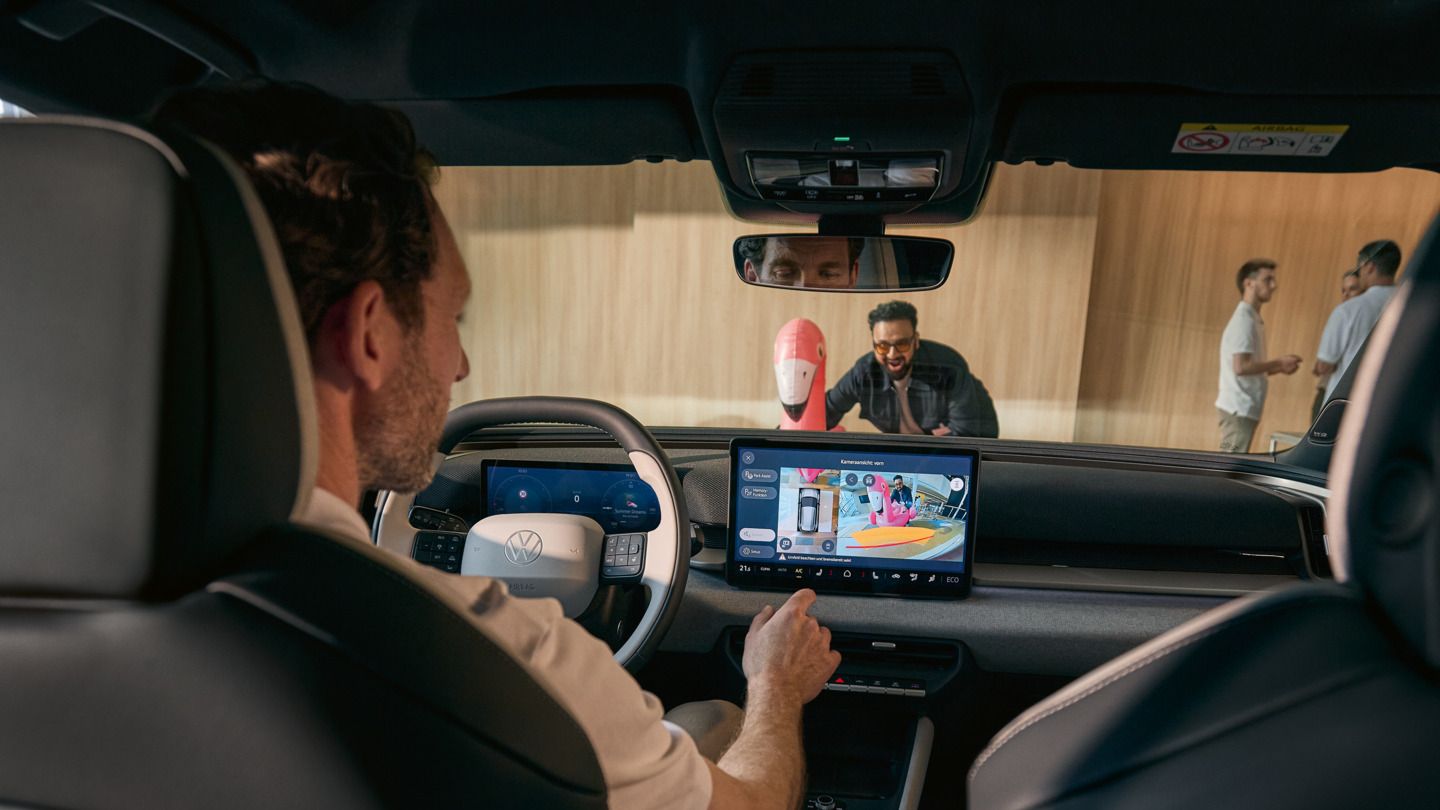 Ein Mann bedient den Infotainment-Screen des VW ID. Cross, auf dem Bildschirm wird die Ansicht der 360° Frontkamera gezeigt.