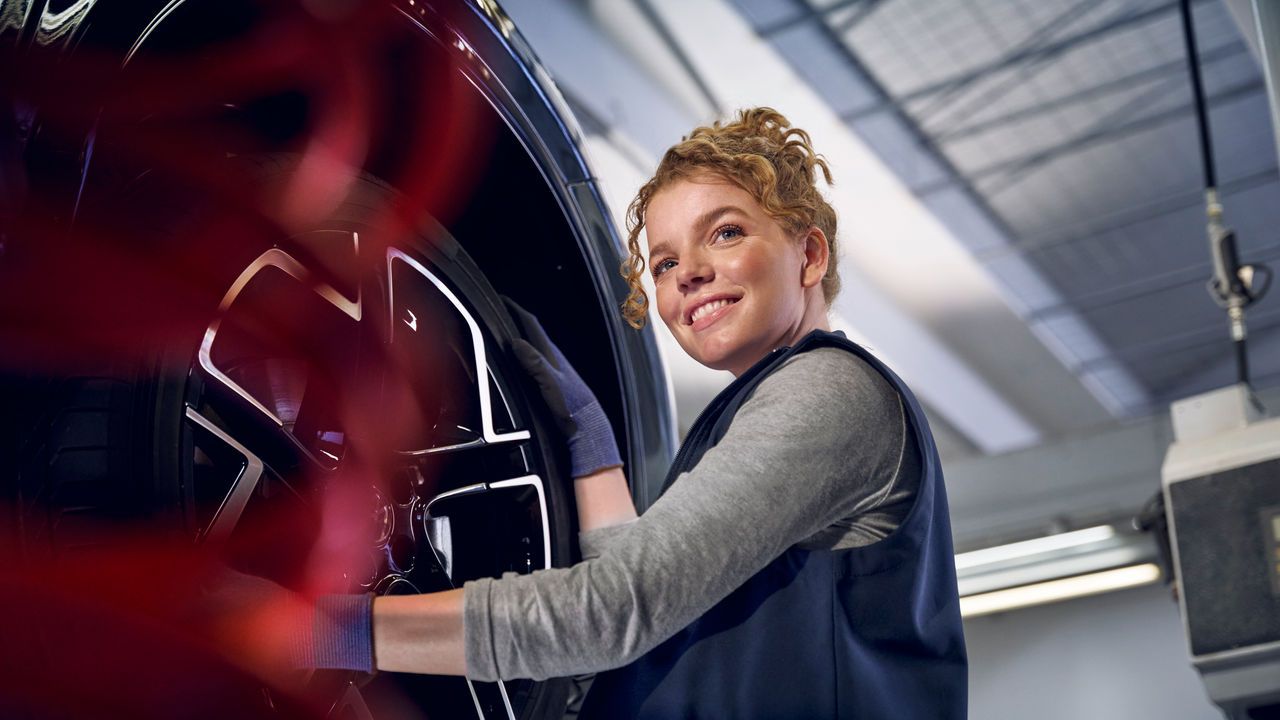 Eine Volkswagen Technikerin beim Reifenwechsel