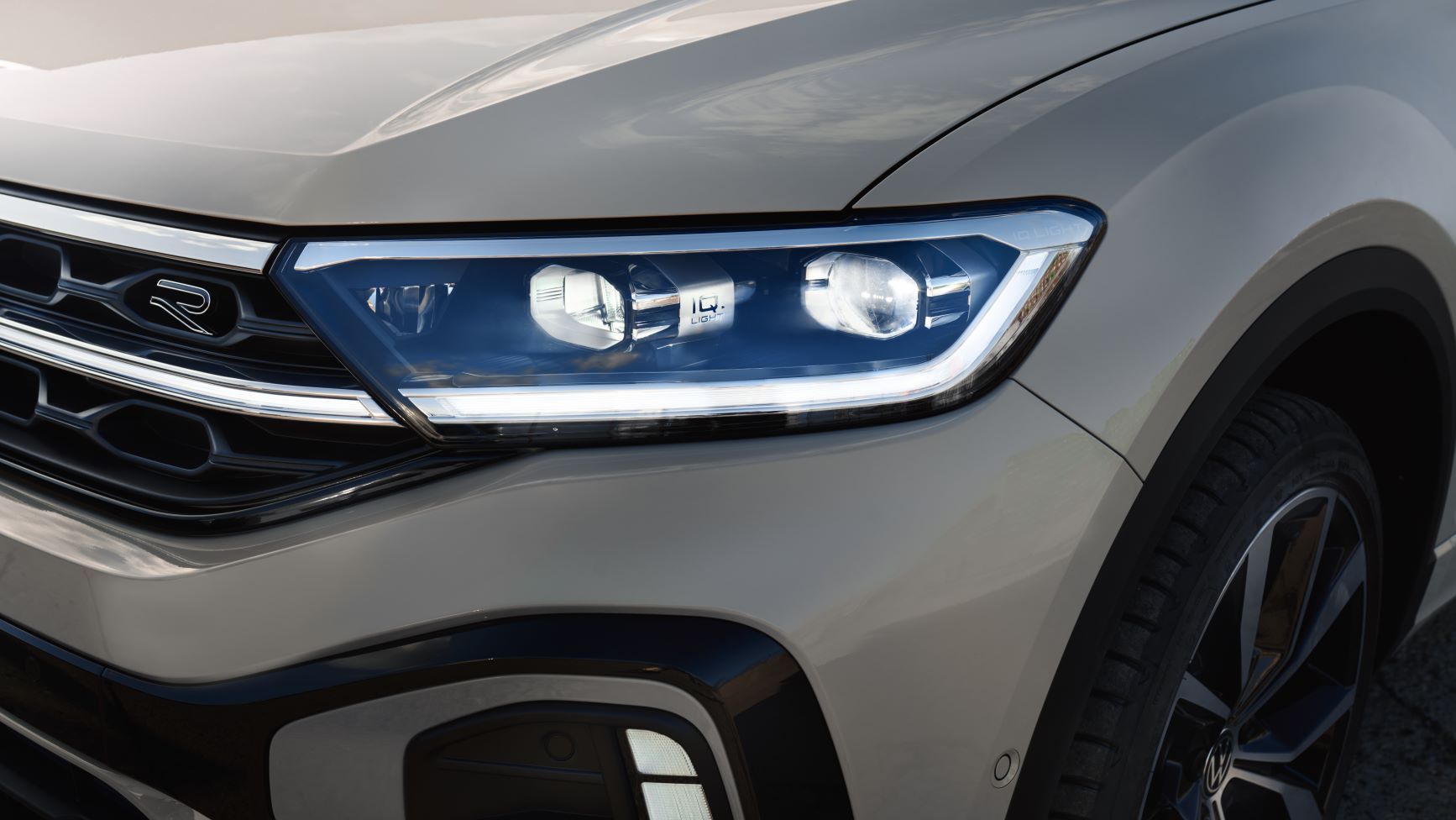 Parte frontală a unui VW T-Roc R-Line de culoare albă, vedere detaliată a sistemului IQ.LIGHT
